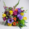 Bright, colorful arrangement of lavender, yellow, pink, orange and bright green blooms.