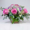 A romantic  arrangement featuring six soft pink roses, elegantly accented with