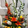 Basket arrangement filled with hydrangea, snap dragons, roses, stock, curly willow and