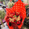 A dozen long stem red roses with diamonds and gold butterflies wrapped