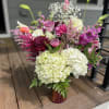 A lavish medley of hydrangeas, vibrant multicolored solidago, elegant lilies, chrysanthum,, and