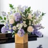 An elegant floral arrangement combining delicate cream roses, airy lisianthus, and soft
