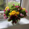 A lush, joyful arrangement bursting with sunshine-yellow roses, rich burgundy alstroemeria and