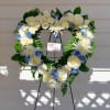 An all white tribute, this white cross funeral spray is pure and