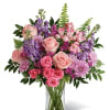 Soft pink roses breathe life into this perfectly feminine arrangement. Bursting with