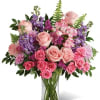 Soft pink roses breathe life into this perfectly feminine arrangement. Bursting with
