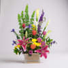 Spring basket of calla lilies, stargazer lilies, larkspur, roses and chrysanthemum poms