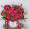 An eye-catching arrangement overflowing with premium peony blooms and textured greenery, artistically
