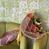 A warm and cheerful bouquet of vibrant tulips wrapped in elegant golden