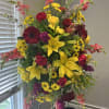 Designers choice of primary colored flowers, arranged in a standing spray. The
