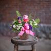 A petite textured jar style vase in assorted spring colors is filled