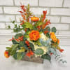 A low wooden box arranged with artificial hydrangea, ranunculus and mixed greenery.