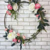 An artificial wreath, hoop, arrangement with hot pink and white florals and
