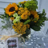 Sunflowers, yarrow, daisies, yellow button poms and green hydrangea arranged in a