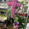A breathtaking standing cross of majestic purple and lavender blooms remembers and