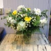 This lush vase features white hydrangea, lemon lime roses and white stock.