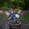 Seasonal blooms arranged in a vintage style embossed keepsake tin planter. Bright