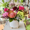 Vibrant, seasonal array of flowers arranged in a ceramic vase.