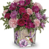 Like a hummingbird flitting around a secret garden, this delightful bouquet of