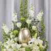 This arrangement has green mums, bells of Ireland, stock, roses, lilies, hydrangea
