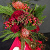 A blend of Protea, roses, Spruce, Yarrow, and Hypericum. This arrangement pulls