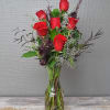 A half dozen red roses with greens and filler. A taller presentation