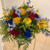 A vibrant floral arrangement bursting with bold colors &mdash; deep blue, bright