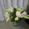 This is a classic white and cream floral arrangement in a clear