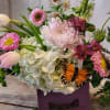 A vintage styled wooden drawer box filled with hydrangea, roses, larkspur, tulips