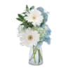 Soft blue and white blooms arranged in a clear vase for a