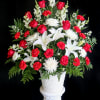 a tall, sophisticated arrangement of red and white in a mache basket