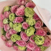 Vibrant pink roses nestled amidst lush, fresh green hydrangeas. Together, they create