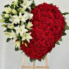 This heart wreath combines red roses, symbolizing love and respect, with delicate