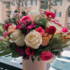 The bouquet includes a mix of white, pink, and deep magenta roses