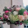 The bouquet includes a mix of white, pink, and deep magenta roses