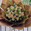 Timeless bouquet featuring elegant white roses nestled among lush, fresh greenery. This