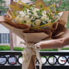 Timeless bouquet featuring elegant white roses nestled among lush, fresh greenery. This