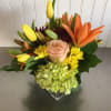 In a low, square, glass vase, this arrangement will include seasonal blooms
