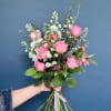 Soft pink roses, baby&rsquo;s breath, and fresh greens create this light and