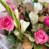 A front-facing bouquet with hot pink, white, and brown tones, wrapped in