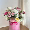 A tall, round pink velvet box filled with pink, light pink, and