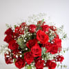 A medium cylinder glass vase with red roses, baby&#039;s breath, and eucalyptus.