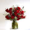 A medium cylinder glass vase with red roses, baby&#039;s breath, and eucalyptus.