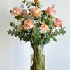 A tall cylinder glass vase with roses, eucalyptus, and baby&#039;s breath. 

Flower