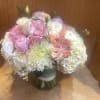 A beautiful assortment of peachy blushy flowers arranged in a clear glass