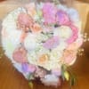 A beautiful assortment of peachy blushy flowers arranged in a clear glass