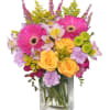 The arrangement features a rectangular vase filled with an array of vibrant
