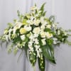 Angelic casket arrangement in white tones with greens.