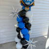 a tower of blue, black and white balloons topped with a Ballon