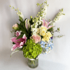 An arrangement of pink roses, hydrangea, stargazer lilies, and larkspur. 